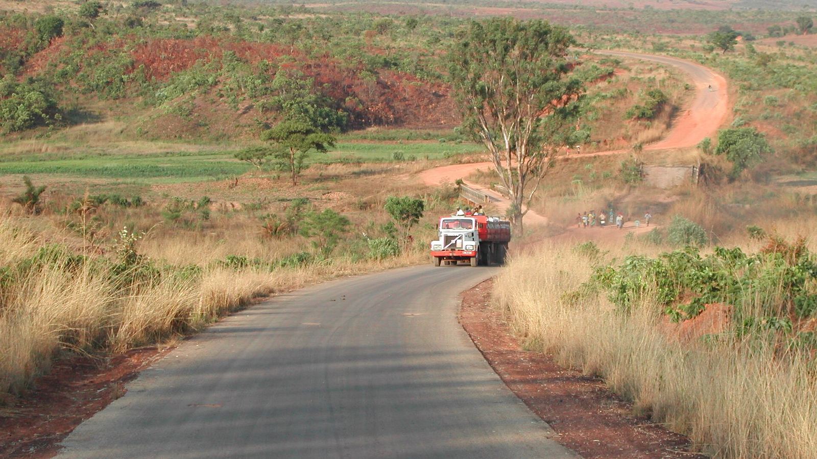 Paved road with a truck, laterite track and temporary bridge between Ukuma and Huambo, Huambo Province, Angola