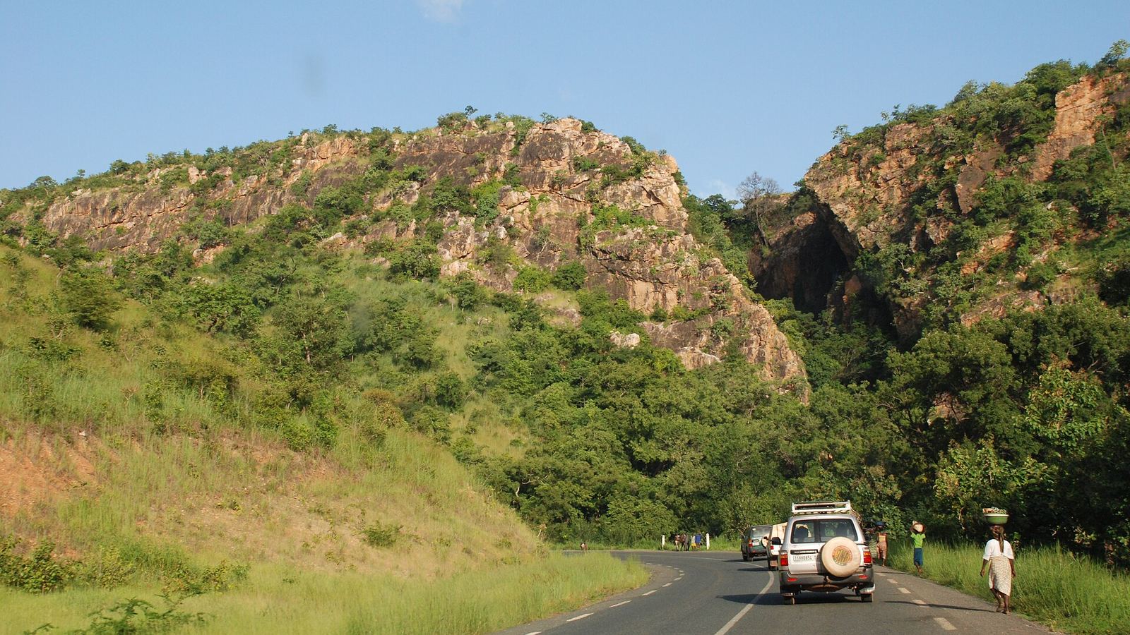RNIE 3 highway through rocky hills near Tangieta, Atakora Province, Benin, with a 4x4 on the road