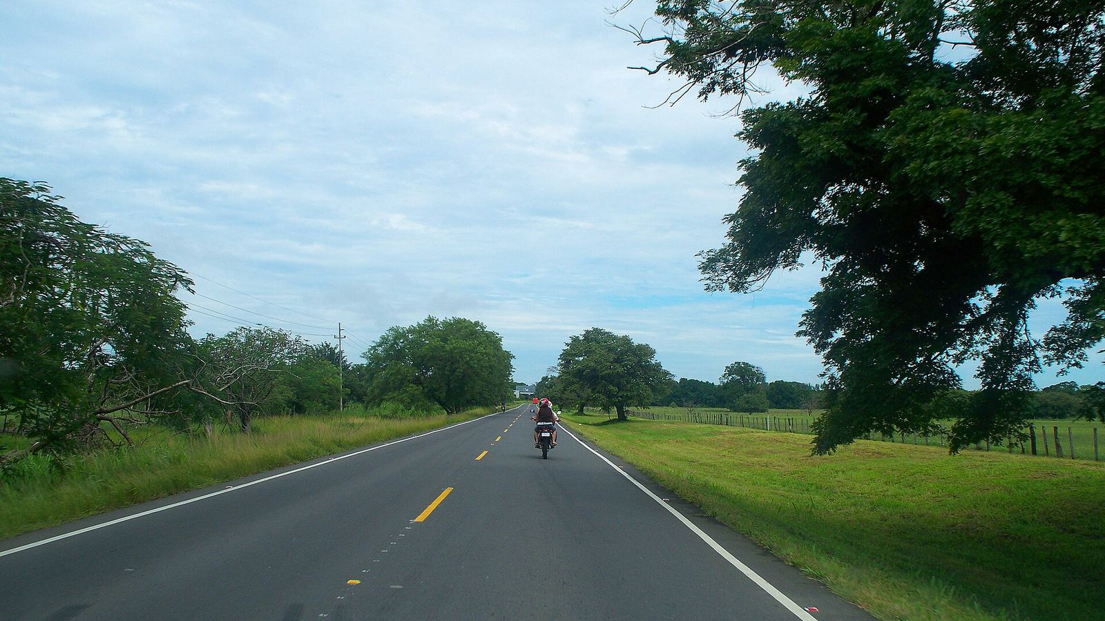 Pan-American Highway through Guanacaste, Costa Rica, a motorbike far ahead