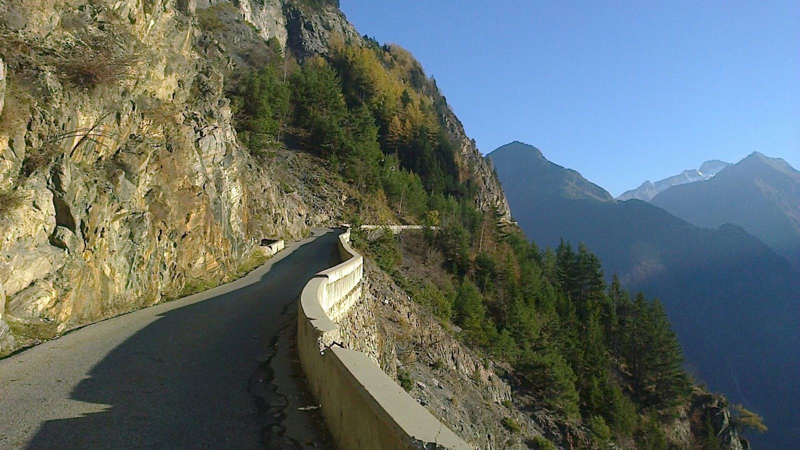 Narrow cliffside mountain road with parapet in Isere, French Alps, France