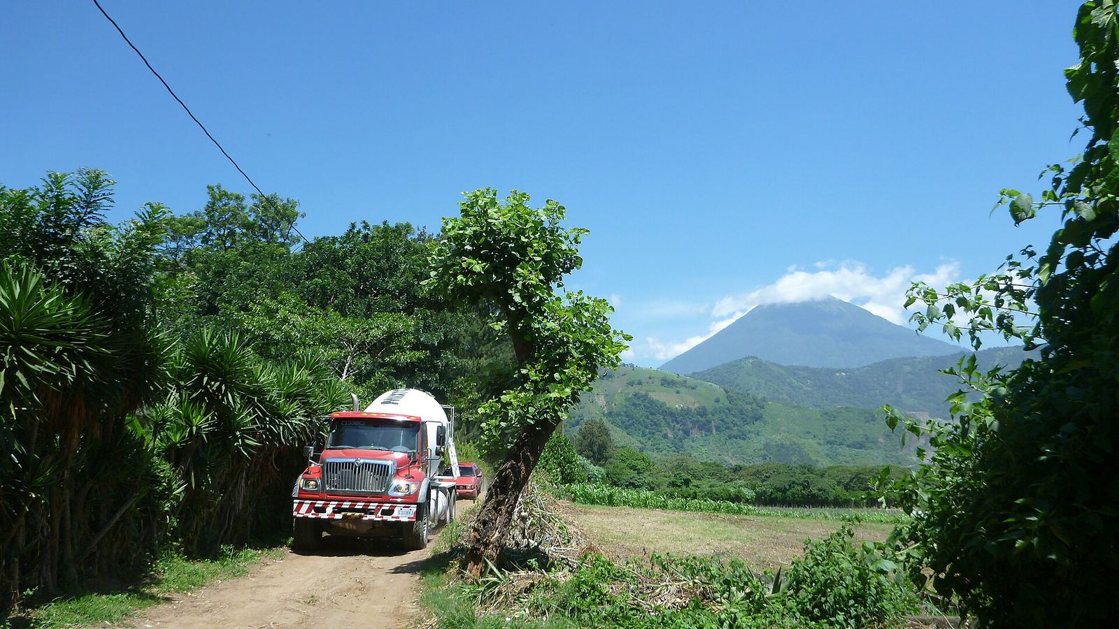 Dirt road with a cement mixer truck and a volcano in the background, Escuintla Department