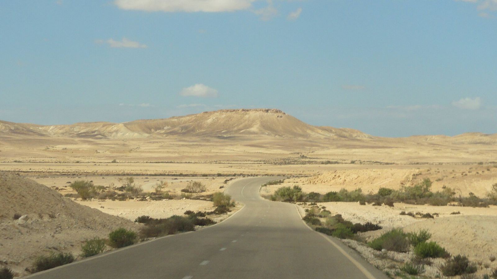 Empty desert road towards a mesa in the Negev