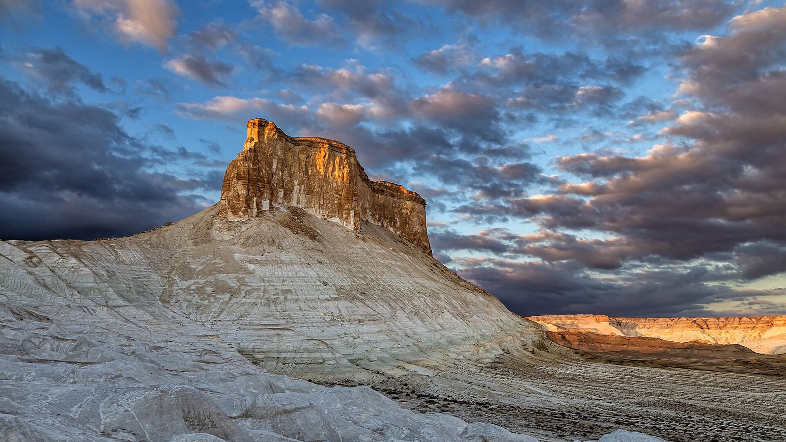 White chalk slope and sandstone butte at sunset in the Bozjyra tract, Mangystau