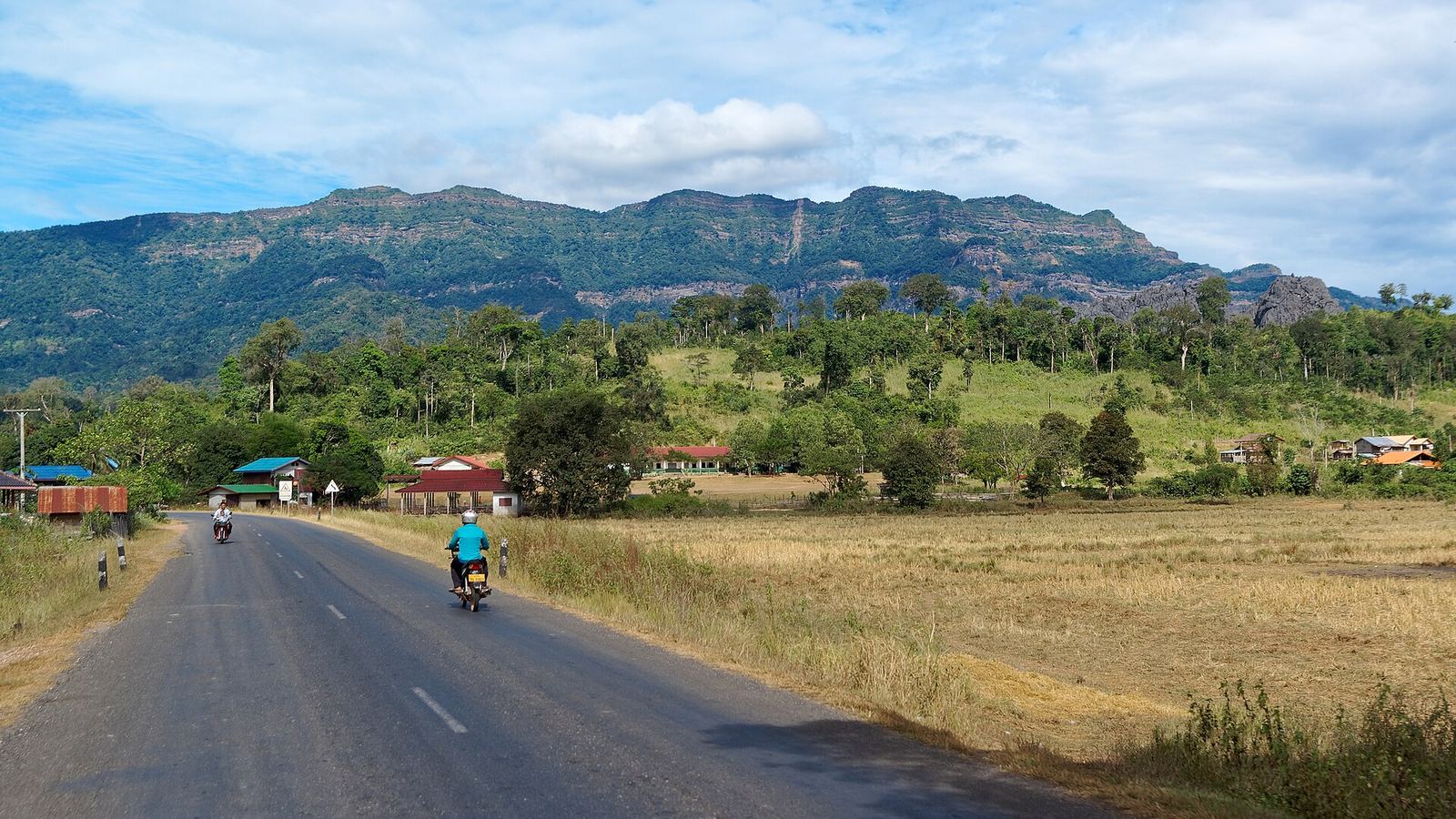 Route 8 winding through hills with motorbikes and villages, Bolikhamsai Province