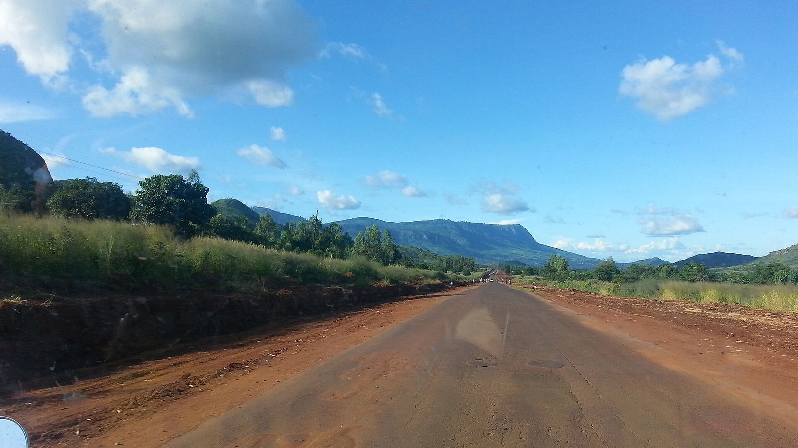 Red-earth road towards the Zomba Plateau seen through the windscreen