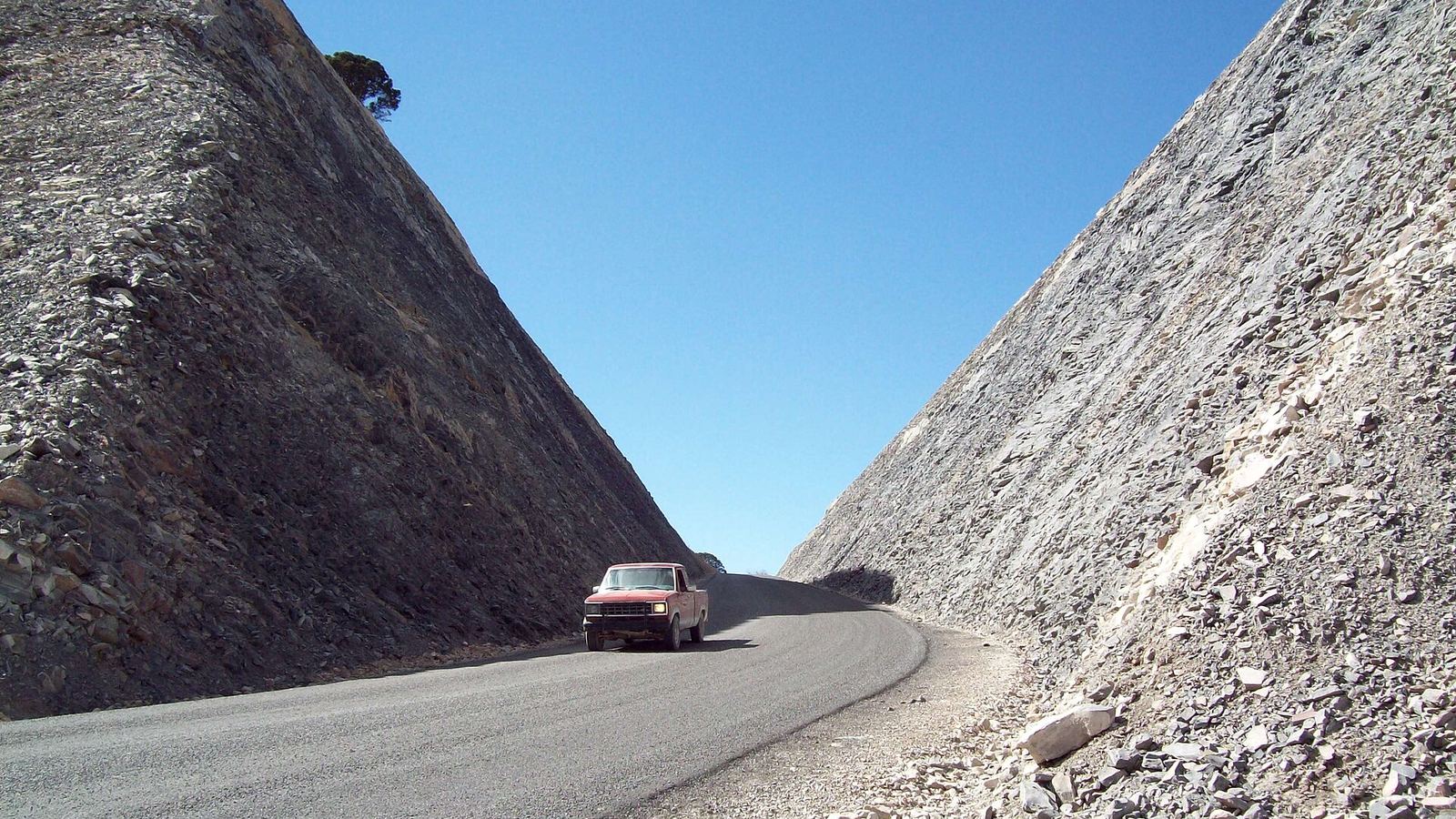 Road cut through rock on the Pabellon-Mazapil road, Zacatecas, with a pickup