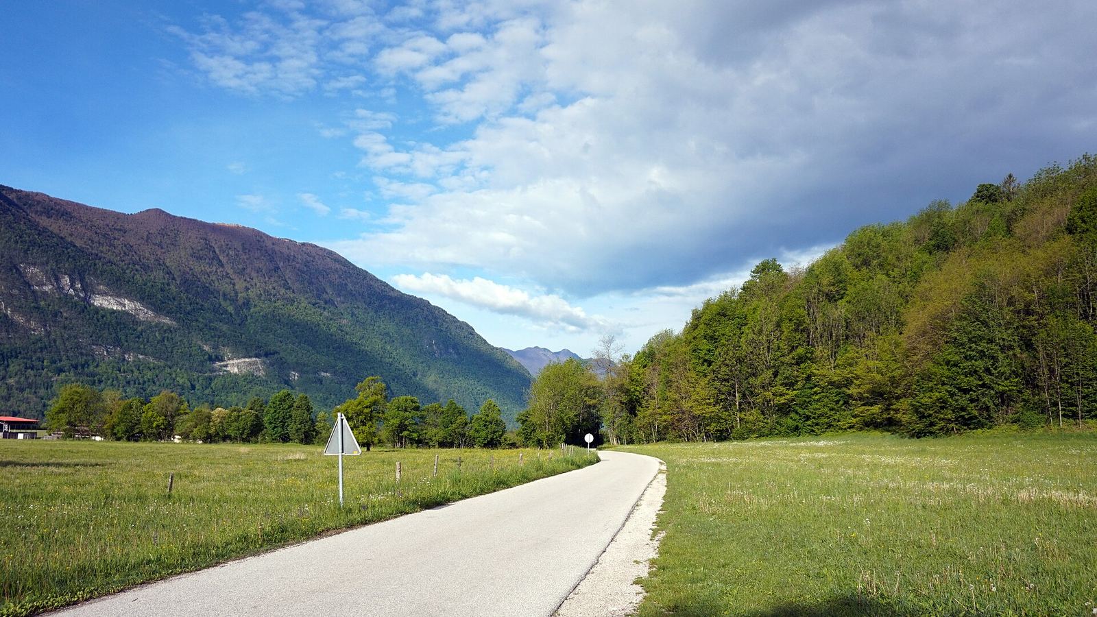 Narrow paved road in the valley below Polovnik ridge near Bovec, Julian Alps, Slovenia