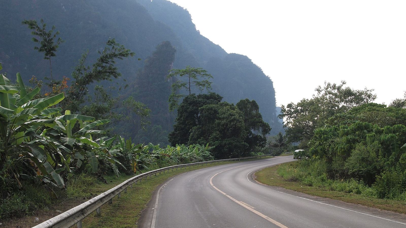 Highway 401 curving below forested karst hills in Khlong Phanom National Park, Surat Thani, Thailand
