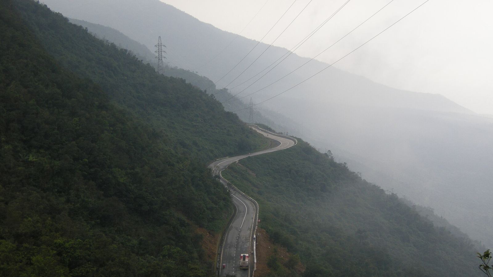 Winding road of the Hai Van Pass in mist with a lorry, Da Nang, Vietnam
