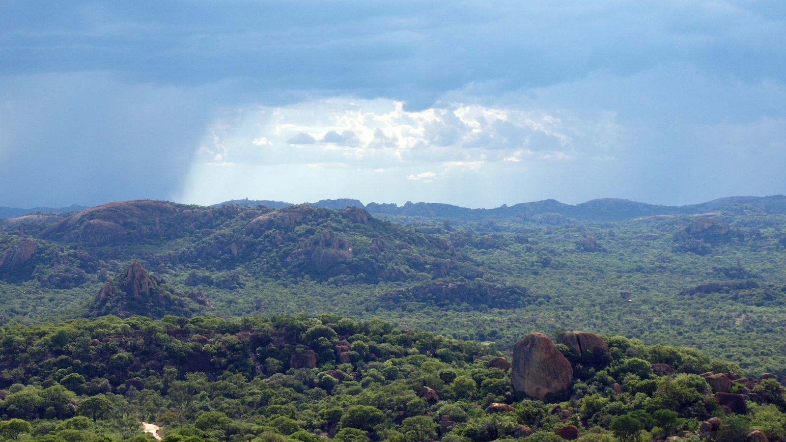 Granite kopjes and boulders of the Matobo Hills under a passing rain shower, Matobo National Park, Matabeleland South