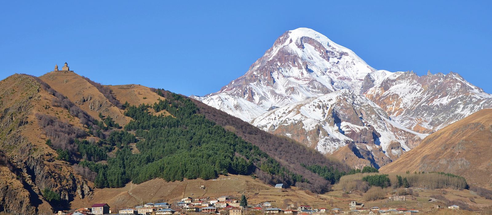Snow-covered Mount Kazbek above the village of Stepantsminda