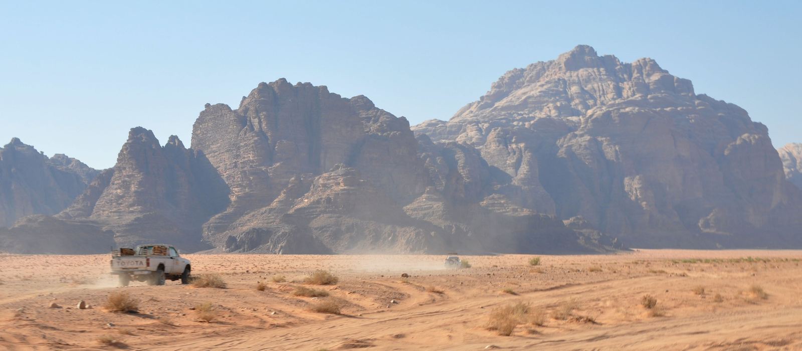 Un pick-up 4x4 nella sabbia, sotto le montagne di arenaria del Wadi Rum